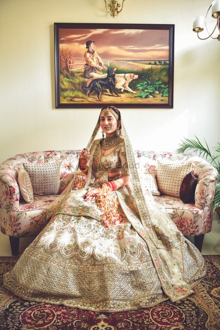 A regal Sikh bride in ivory lehenga on her wedding day.