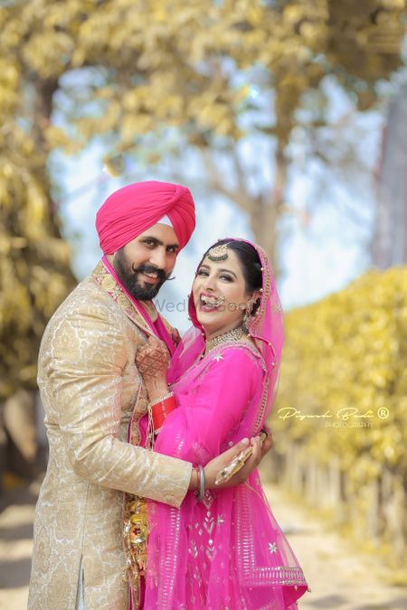 Photo of A sikh bride and groom pose after their wedding