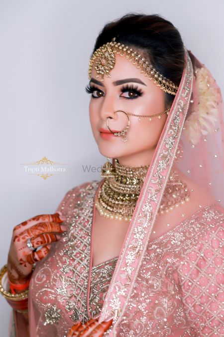 A bride in soft pink lehenga and subtle makeup 