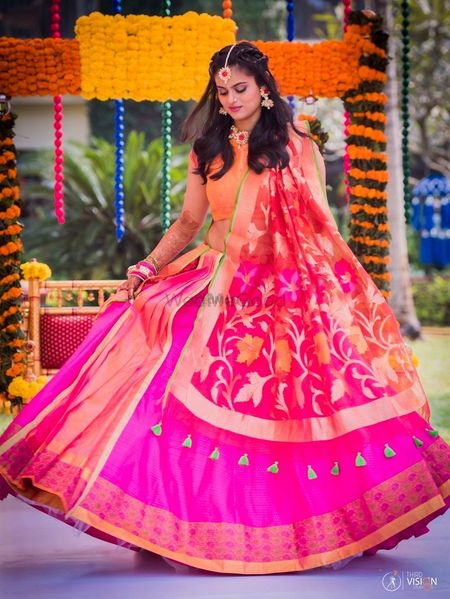 Bride to be in pink lehenga with Benarasi dupatta and floral jewellery
