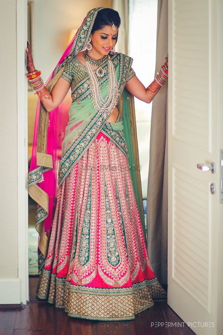 Bride in mint and bright pink bridal lehnega 