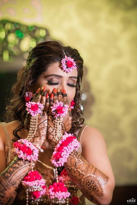 A bride-to-be flaunting her floral hathphool on her mehendi day