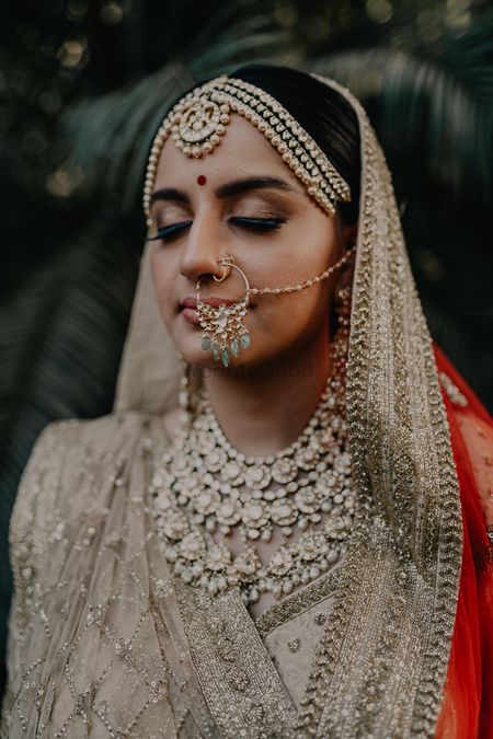 bride showing off her nath and her necklace 
