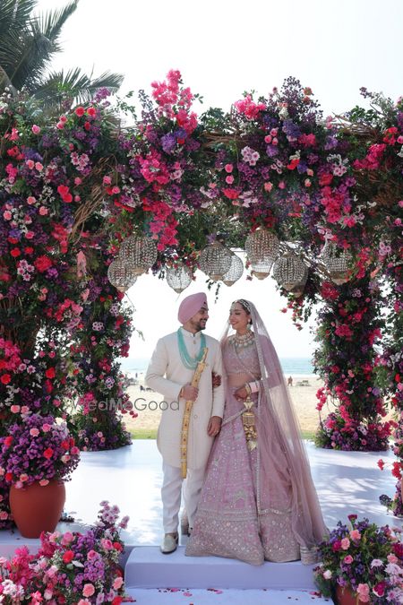Photo of Lovely floral mandap in pink and purple flowers for an outdoor wedding