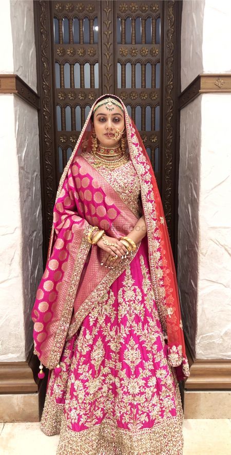 A bride in pink lehenga with a banarasi dupatta 