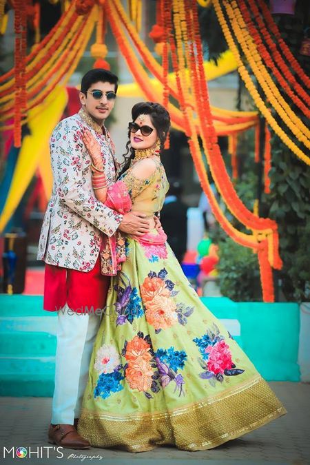 Bride and groom in floral prints for their mehendi function