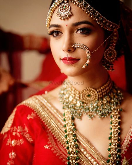 Photo of Bride wearing a red lehenga with polki jewellery.