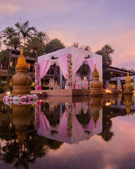 Light pink mandap with drapes by seaside 