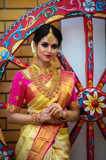 South Indian bride wearing yellow saree with a pink blouse