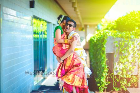 Fun south Indian couple portrait with groom picking bride 