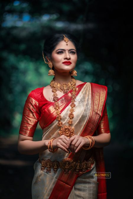 An elegant bridal shot in Bengali saree and temple jewellery. 