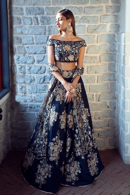 An off-shoulder engagement lehenga coupled with heavy earrings. 