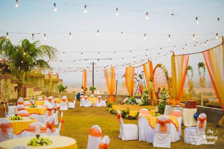 Photo of Orange and yellow theme outdoor round table setting