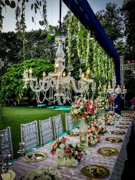 Intimate long table setting with hanging chandeliers