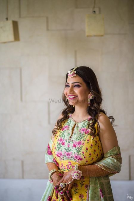 Photo of A bride in a light lehenga and floral jewellery for her mehndi