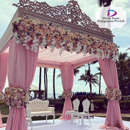 A light pink curtained mandap with floral decor