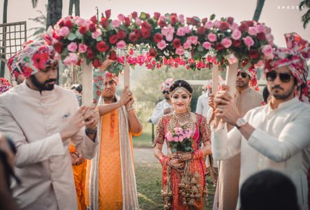 Bride holding bouquet entering under chadar 