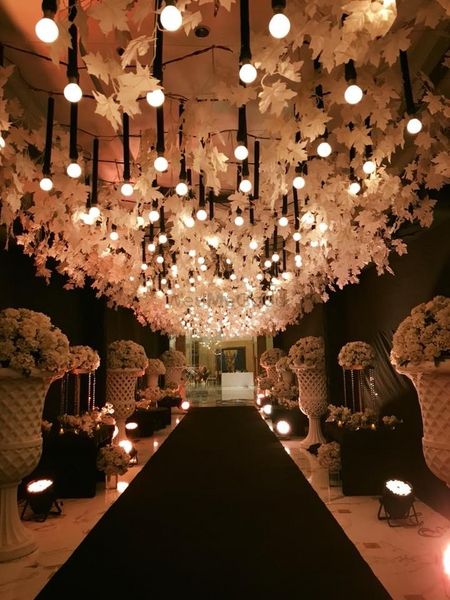Suspended bulbs and floral strings for entrance decor.
