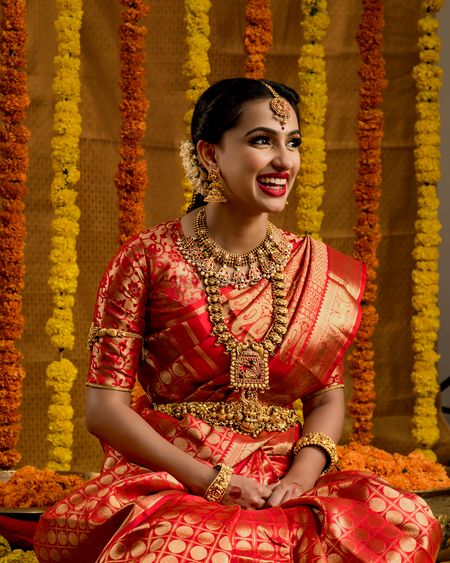 A south Indian bride in a jewel-tone kanjeevaram and stunning temple jewellery