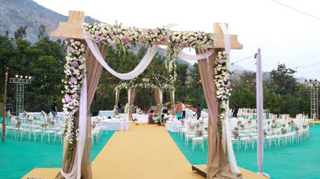 Photo of Wooden entrance decorated with flowers and drapes.