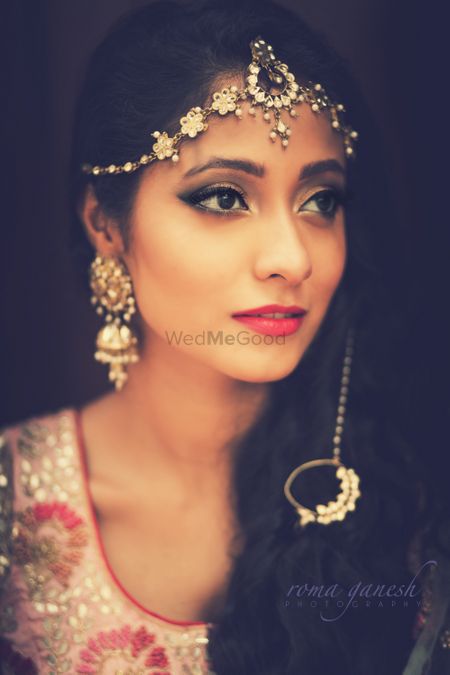 Photo of Bride wearing delicate mathapatti with dropped nath