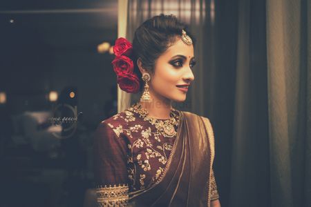 Photo of Beautiful bronze saree with bridal bun with red roses