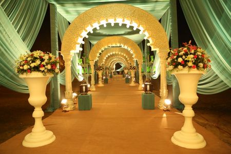 Archway entrance decor with floral vases and drapes.