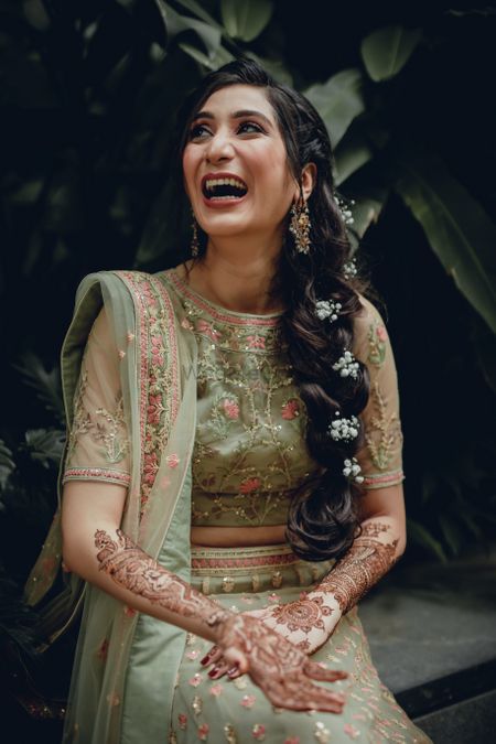 A happy bride wearing a side braid with baby's breaths.