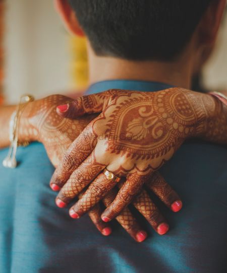 Engagement announcement photo with ring on mehendi hands 
