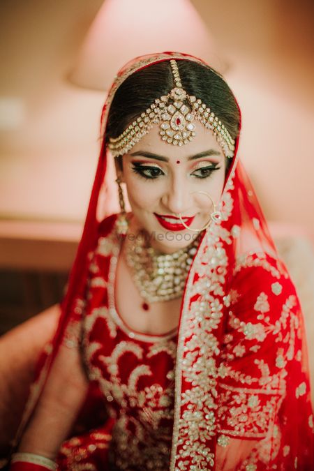 Photo of Bride in red wearing mathapatti and red ipstick