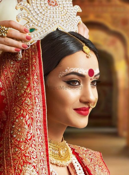 Photo of A beautiful Bengali bride in soft & subtle makeup.