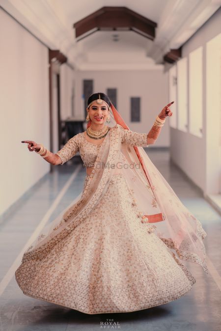 Twirling bride in white and gold lehenga