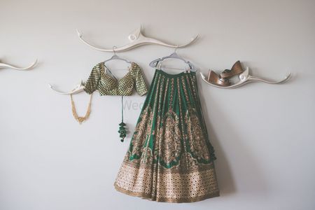 Offbeat bridal lehnega on hanger in green and gold 