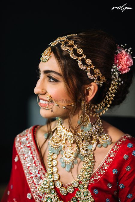 Photo of Brude wearing a pastel jewellery necklace with red lehenga