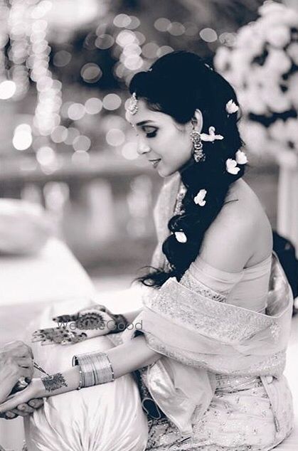 Black and white bridal portrait of bride getting mehendi put