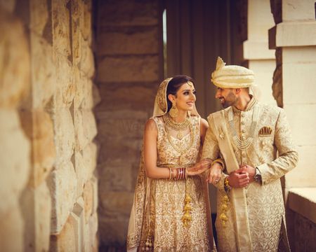 Colour coordinated bride and groom in ivory outfits