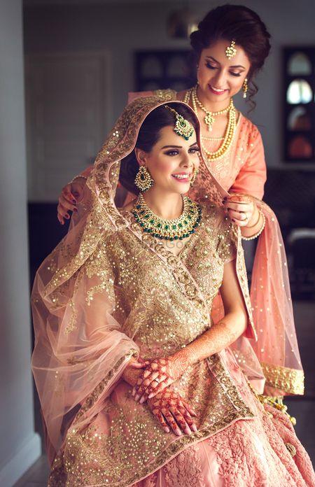 Bride with sister placing dupatta on head