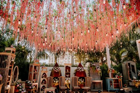 A pretty mandap setup with floral strings hanging from the ceiling 