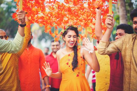 Orange phoolon ki chadar with bride under it