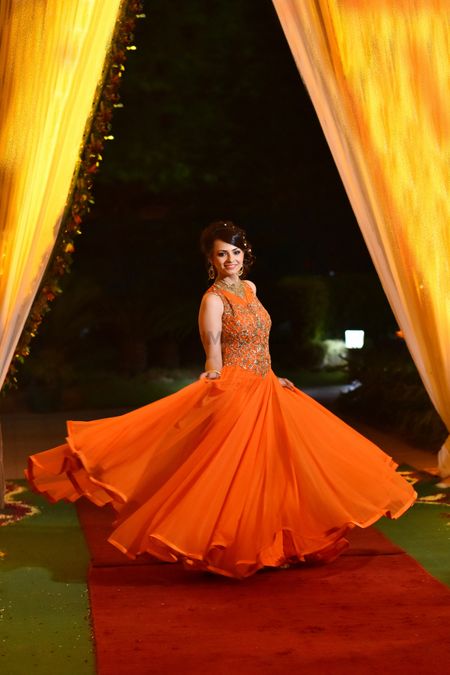 Bride twirling in orange gown