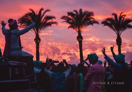 Photo of sunset baraat photo with groom dancing