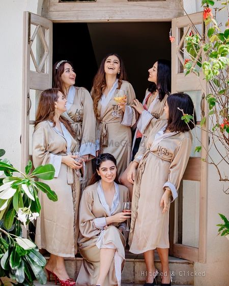 Photo of bride and bridesmaids wearing matching robes for bachelorette