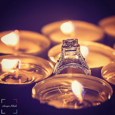 Engagement ring photographed with candles