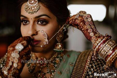 bridal close up shot with her putting on her nath