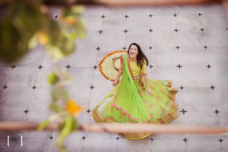 Bride twirling in green lehenga with yellow blouse