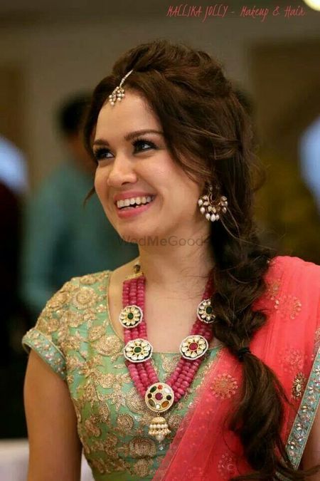 Bride on mehendi with side braid and stone necklace