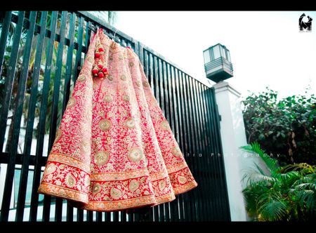 Bright Pink Lehenga with Red Border on Hanger on Gate