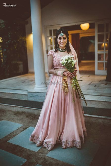Bride in Blush Pink Bridal Lehenga with Bouquet