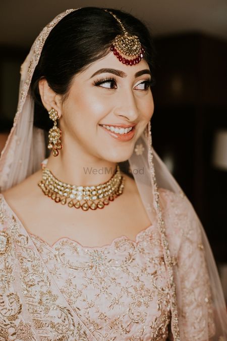 A happy bridal shot in a beautiful pastel lehenga and subtle makeup. 