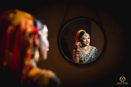 Photo of Bridal getting ready shot in mirror blue lehenga